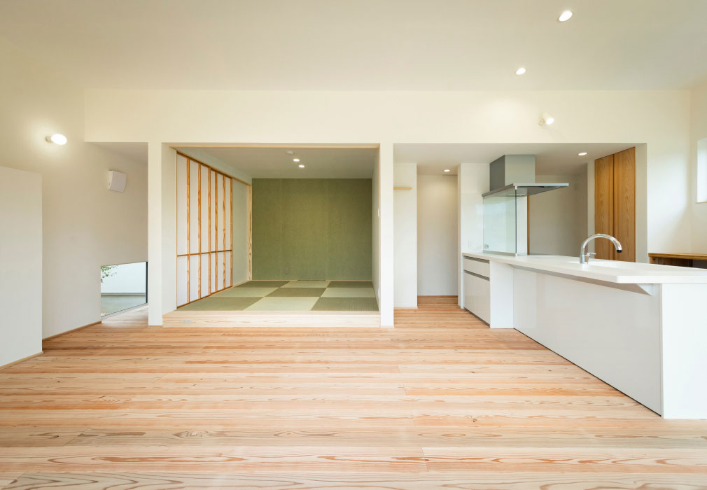 和室と白いキッチンがある自然素材のリビング写真